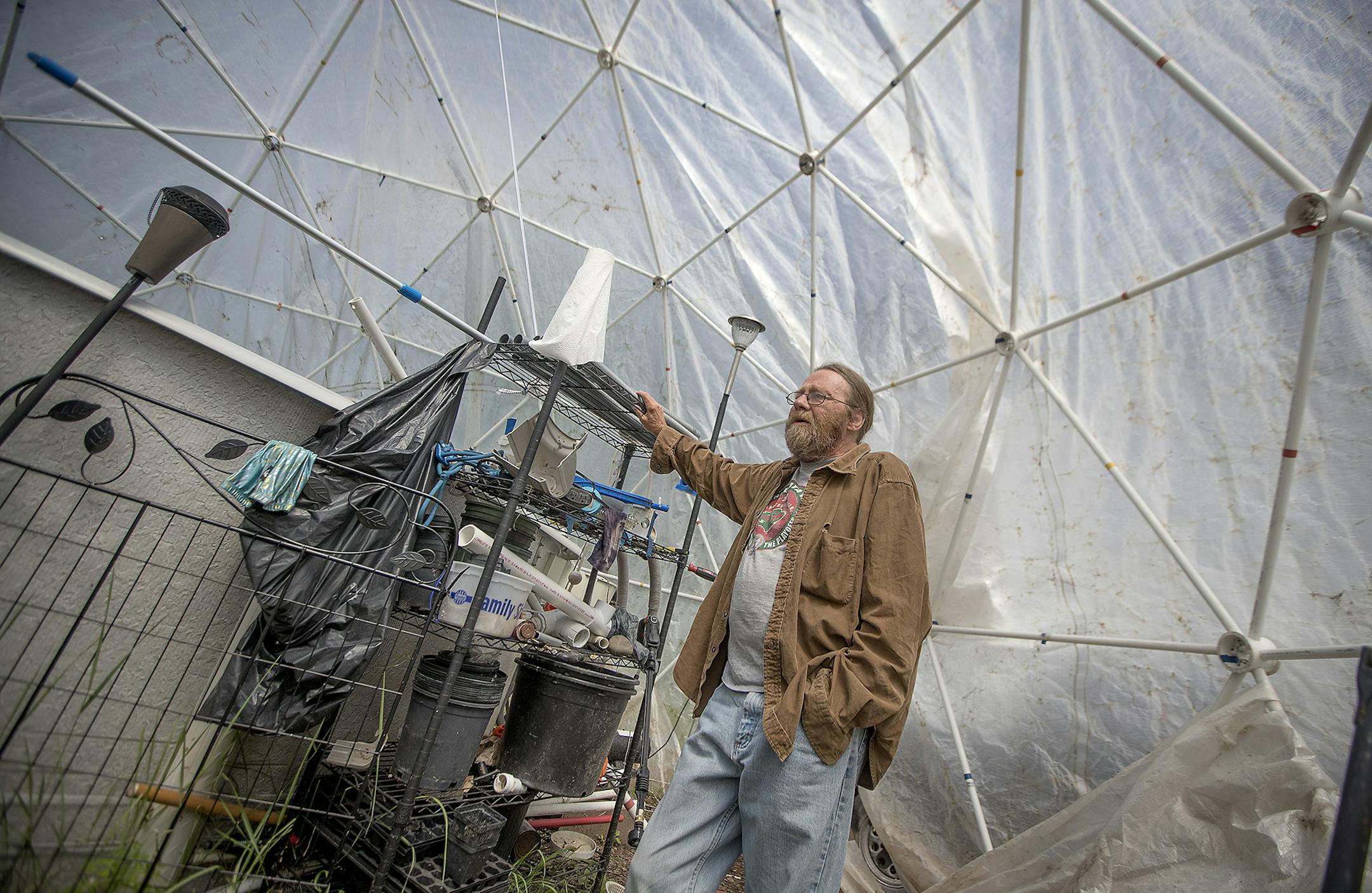 Inside his makeshift greenhouse, Mike Allen has placed a swimming pool for his grandkids. Wednesday, July 18, 2018 in Marble, MN. Allen has found himself in an ongoing battle with city officials who are unhappy that his grass is sometimes too tall, that he keeps a homemade greenhouse and has a half-dozen unlicensed cars in his yard. A former City Council member put up a Facebook post recently, calling him a beer-drinking slob who's dragging down property values, Allen fired back. He's suing her