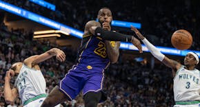 Los Angeles Lakers forward LeBron James (23) pass the ball around Minnesota Timberwolves forward Jaden McDaniels (3) in the fourth quarter Saturday De