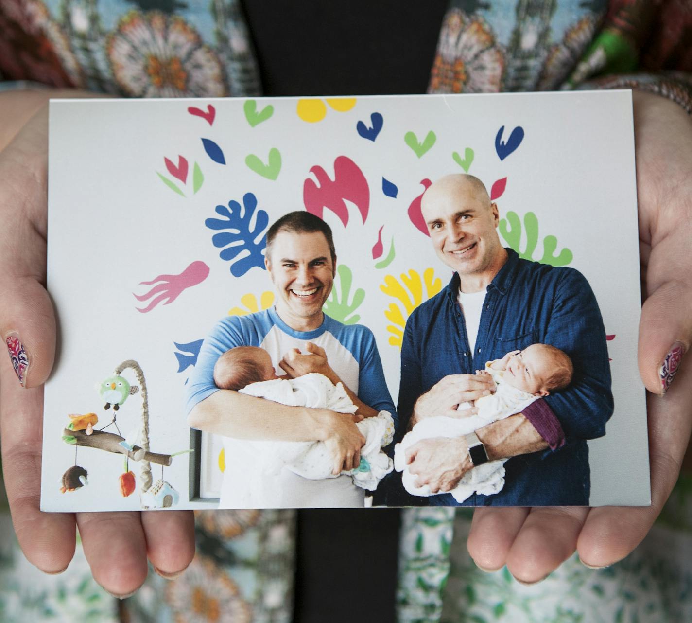 Claire Nielsen holds a photo of the twins she carried, held in the photo by their parents, at her home in Maple Grove June 9, 2015. Claire carried twins as a gestational surrogate for a California couple and gave birth to them in December of 2014. (Courtney Perry/Special to the Star Tribune)