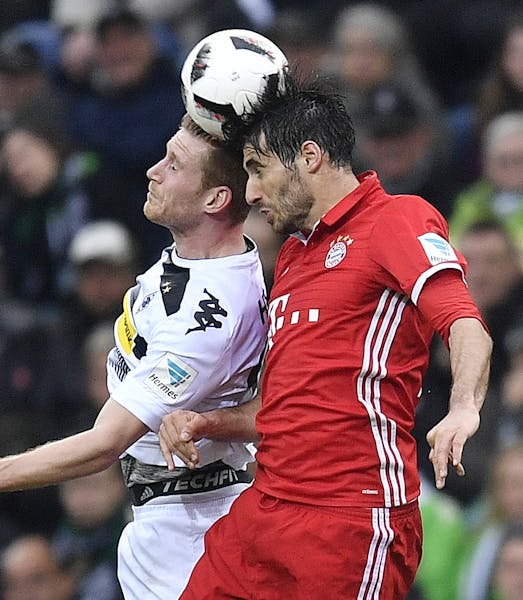 Moenchengladbach's Andre Hahn, left, and Bayern's Javi Martinez challenge for the ball during the German Bundesliga soccer match between Borussia Moen