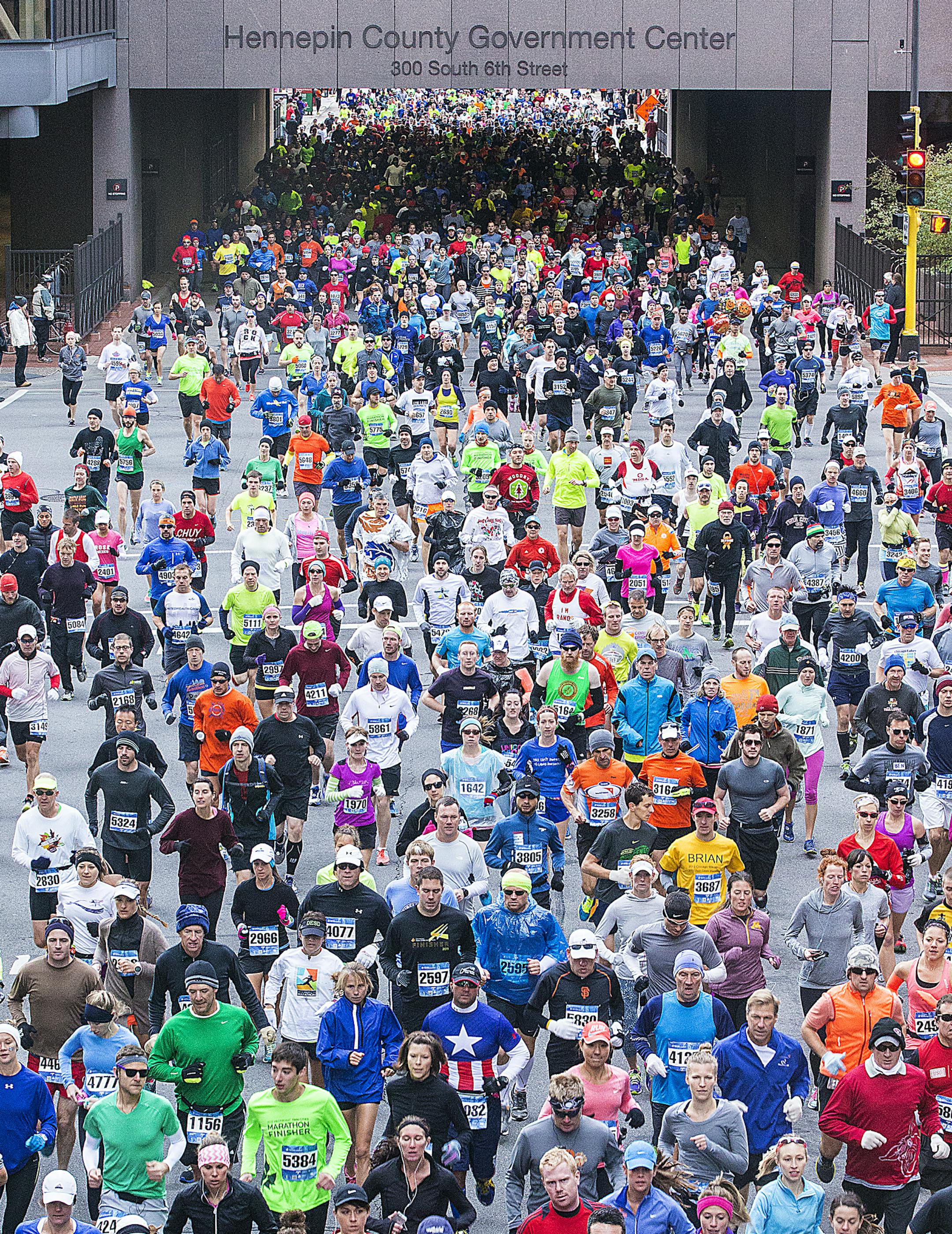 The beginning of the 2014 Twin Cities Marathon, looking back down sixth street as they come through the Government Center tunnel. Four stages were released starting at 7:55 with the Bikes then three Stages of runners., October 5, 2014 Minneapolis MN. [ Star Tribune photo by Tom Wallace SLUG: MARA100614 ASSIGNMENT: 20036423C spts twin city marathon 100514