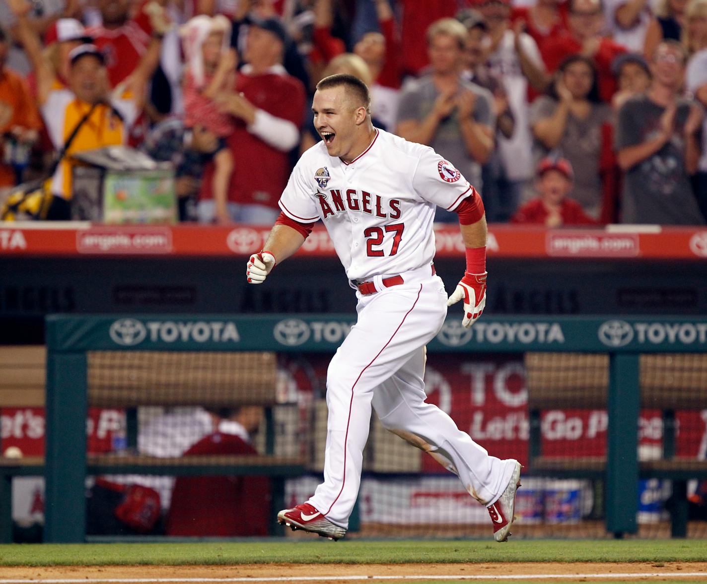 Mike Trout celebrates as he returns to home plate after hitting the game-winning solo home run in the ninth inning of a baseball game against the Houston Astros on Friday, July 4, 2014, in Anaheim, Calif. The Angels won 7-6. (AP Photo/Alex Gallardo)