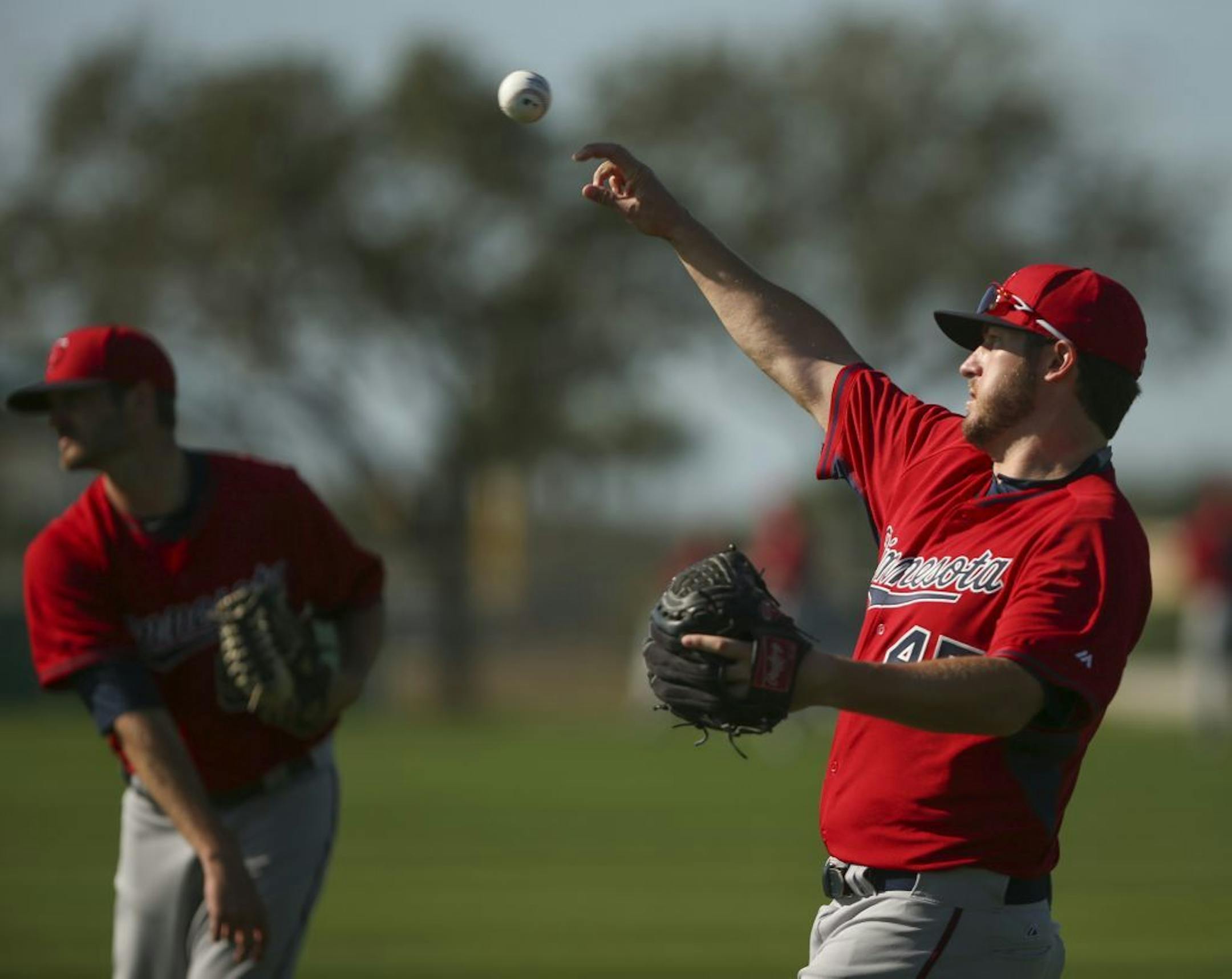 Twins pitchers, including Phil Hughes (45) warmed up playing catch Monday morning at Hammond Stadium.