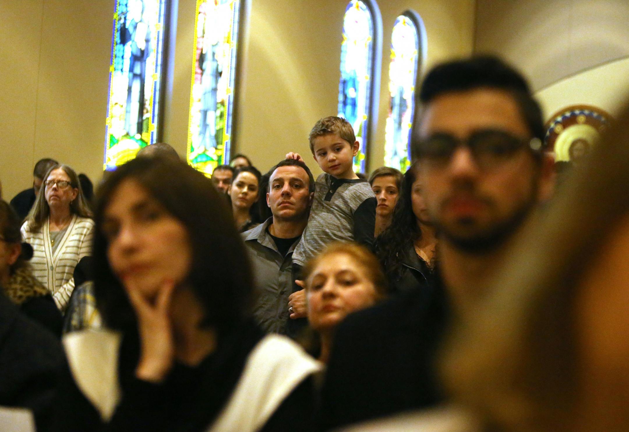John Alexander of Winona, who is of Lebanese descent, holds his son Michael, 4, as worshipers observe the removal of the body of Christ from the cross during a Good Friday service Friday, March 26, 2016, at St. Maron's Catholic Church in Minneapolis.