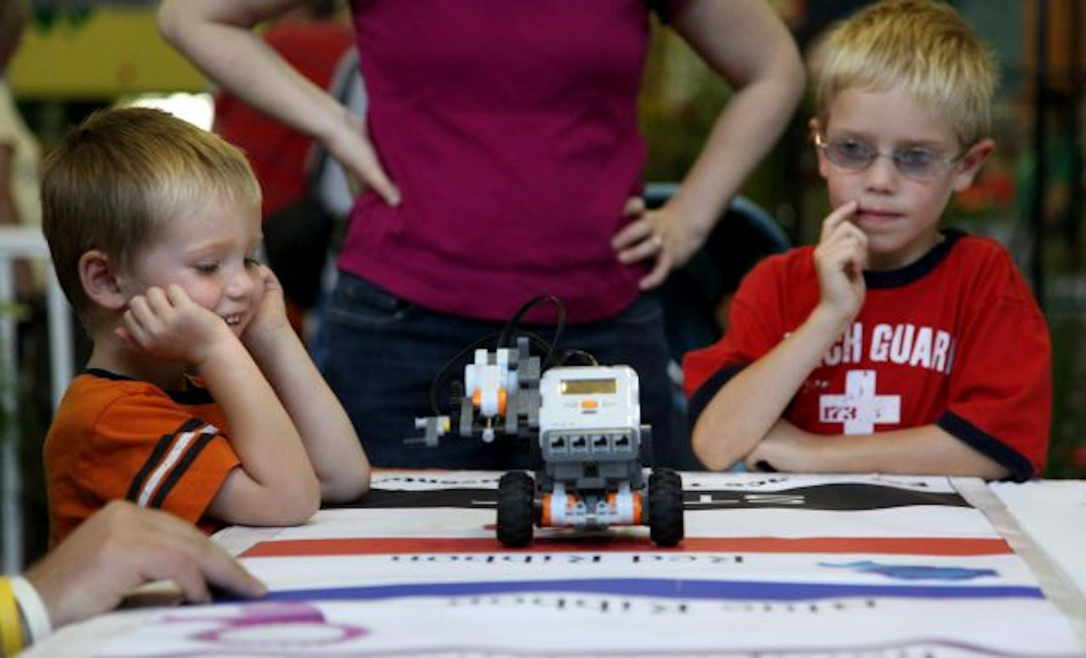 Jack Melbye, 3, and his brother Peter Melbye, 6, of Maple Grove, watched a remote car they had powered drive along a table at a 4-H science and engineering exhibit at the State Fair on Monday.