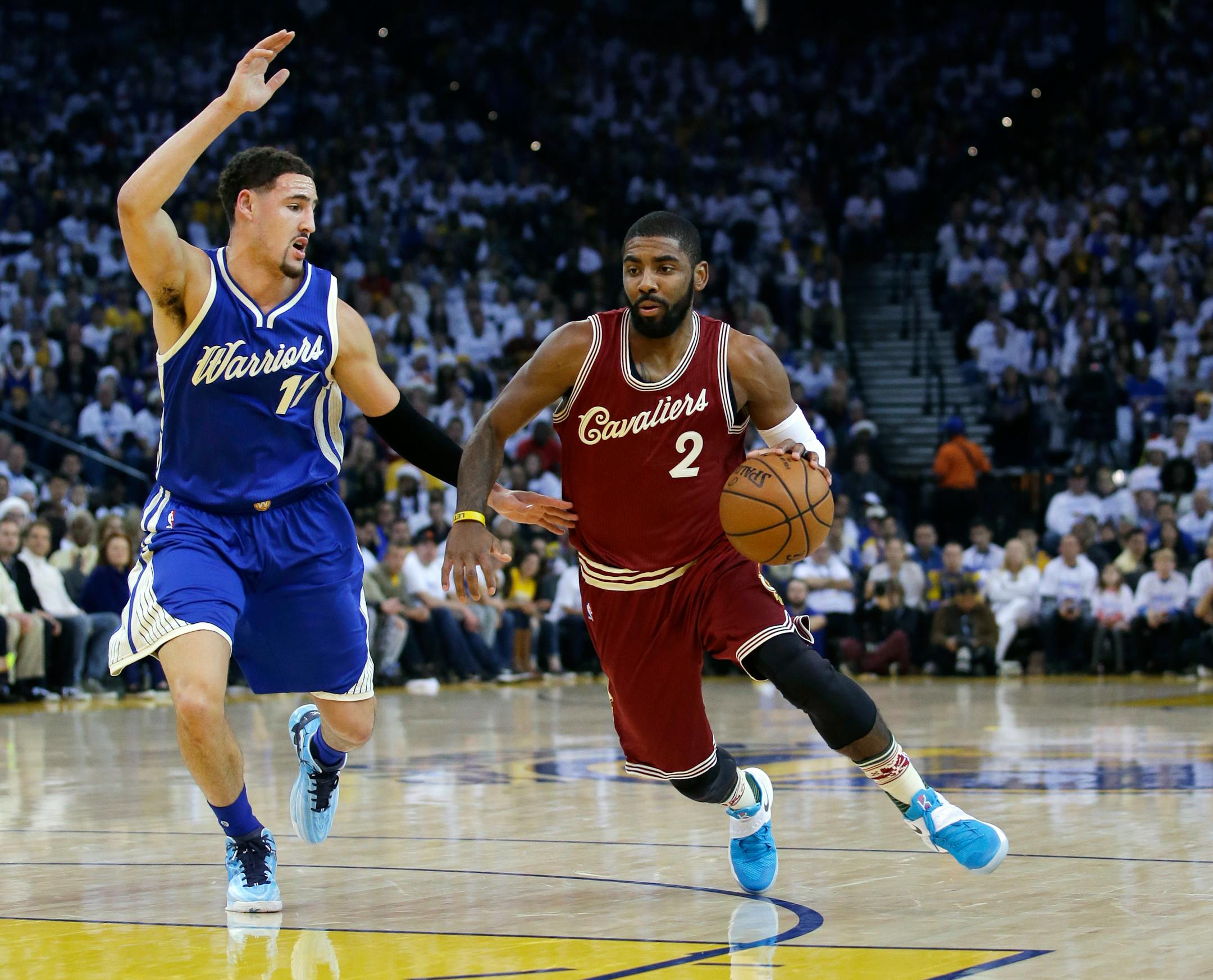 Cleveland Cavaliers' Kyrie Irving (2) dribbles next to Golden State Warriors' Klay Thompson (11) during the first half of an NBA basketball game Friday, Dec. 25, 2015, in Oakland, Calif. (AP Photo/Marcio Jose Sanchez)