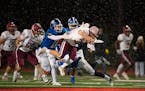 Maple Grove's Tanner Albeck (35) was tripped up by Woodbury's Joey Gerlach (6) with help from Garrett Smith (11) during a first quarter run Thursday, 