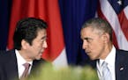 U.S. President Barack Obama, right, and Japan&#xed;s Prime Minister Shinzo Abe, left, talk during a bilateral meeting at the Asia-Pacific Economic Coo