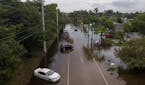 Abandoned cars sit on a flooded North 14th Avenue on Thursday, June 13, 2024, in Hollywood, Florida. Residents in Hollywood woke up to flooded streets