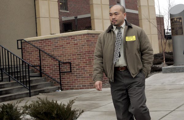 Former St. Paul police officer Tou Cha, walks out of the St. Paul Police department after resigning on Tuesday.