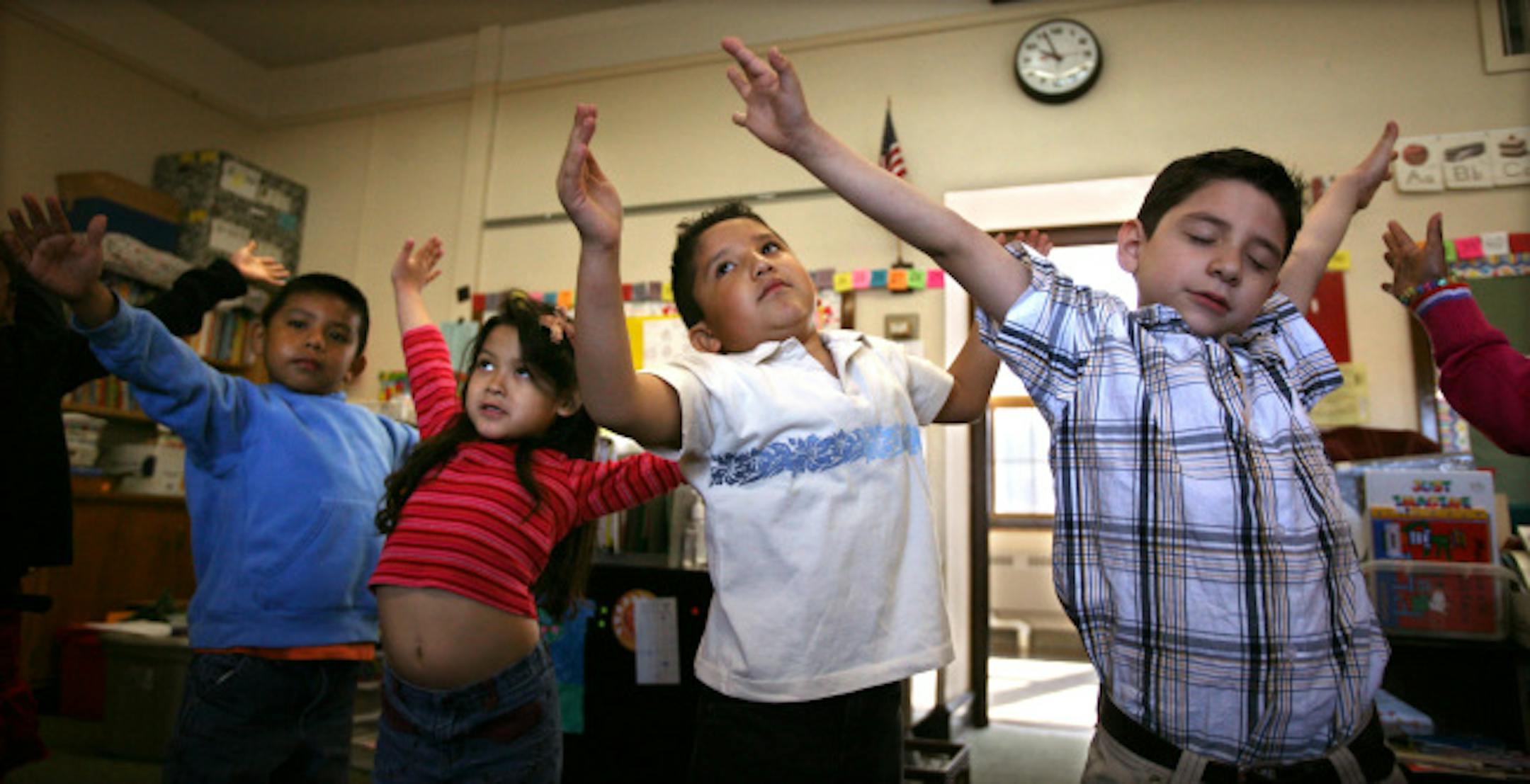 Children in Tammy Mahoney's kindergarten class at Jefferson Community School calm themselves and prepare for the day with a 10 minute yoga session. (L to R) Maybe not in perfect form, but the goal is the same, Cesar Coyote-Aragon, Kymberlee Brown-Chy, Juan Galarza and Jason Verdugo make a "tree" pose.