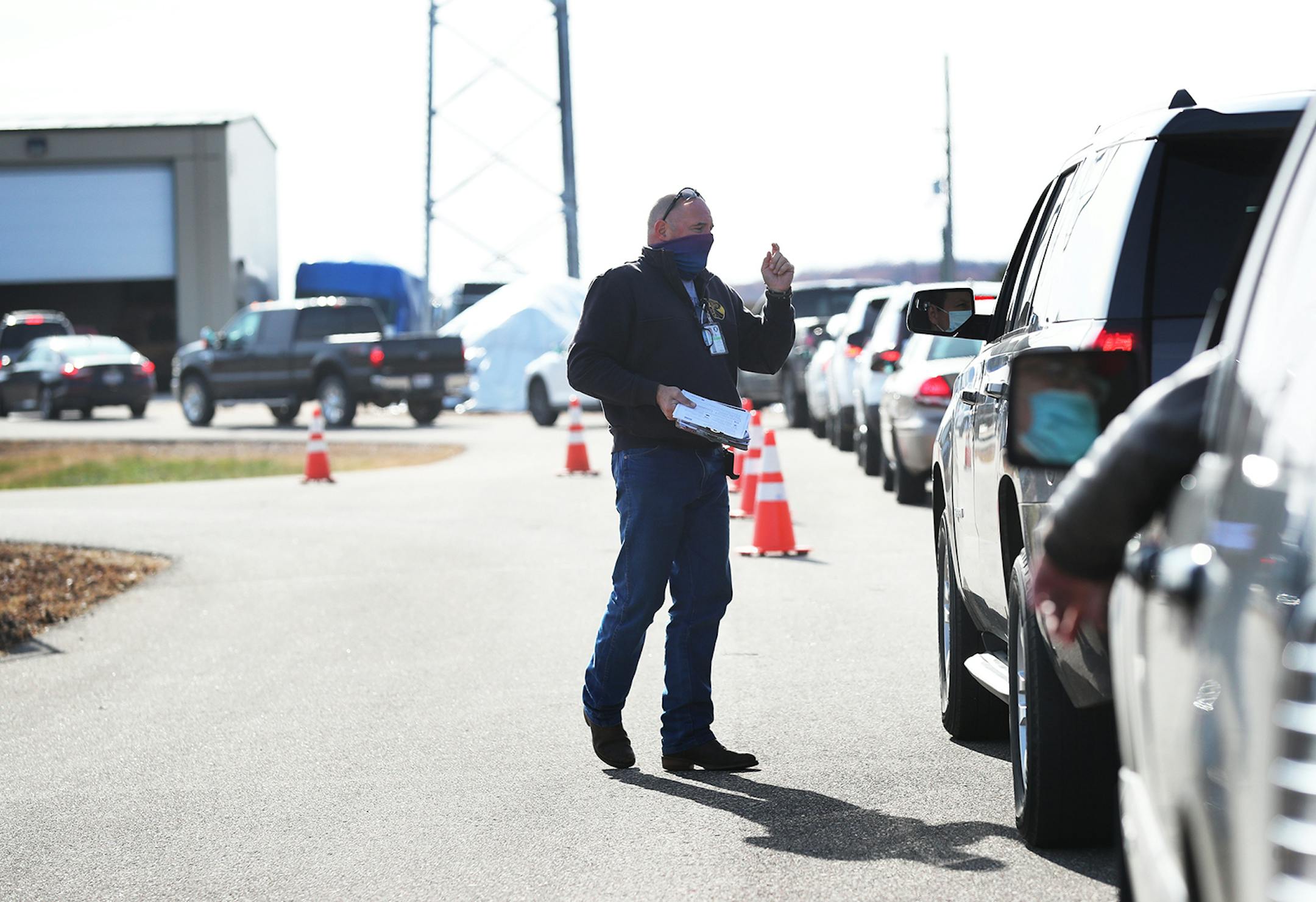 Robert Goodland, the Regional Tracing Advisory Council Coordinator for Northwest Wisconsin, checked the paperwork and checked people waiting in their cars at the free COVID-19 testing site staffed by the Wisconsin National Guard Monday in Eau Claire, WI.
