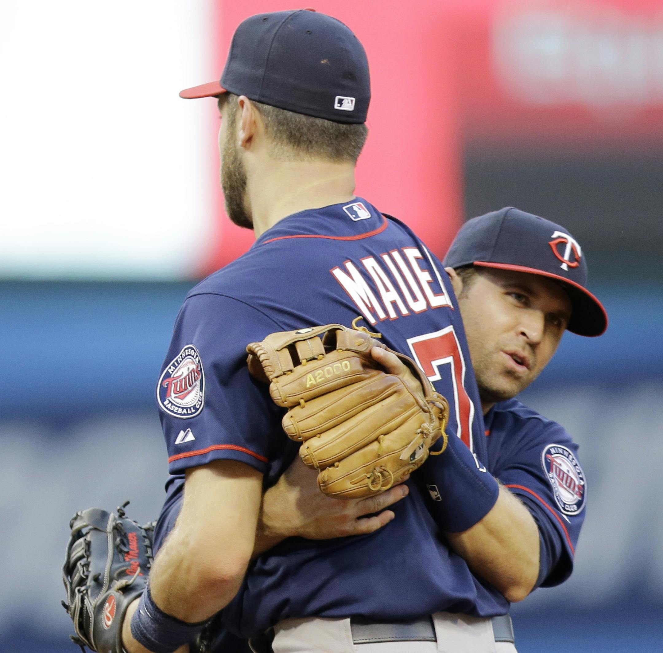 Minnesota Twins' Joe Mauer, left, and Brian Dozier collide as Mauer catches a fly ball hit by Cleveland Indians’ Brett Hayes in the second inning of a baseball game, Friday, May 8, 2015, in Cleveland. Hayes was out on the play.