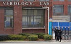 Security personnel gathered near the entrance of the Wuhan Institute of Virology during a visit by the World Health Organization team in Wuhan, China,