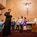 At the parish of Saints Joachim and Anne, the Rev. Erik Lundgren, left, and the Rev. Paul Haverstock lead a group of children in a skit in Spanish on 