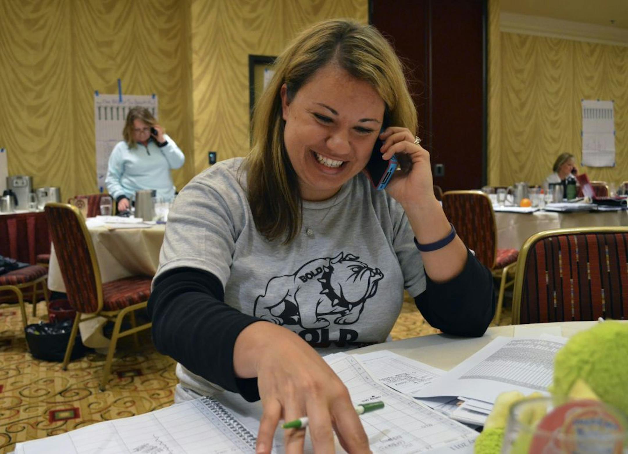 During a training session lecture break Olivia Manson talks to a client. Other Keller Williams agents can be seen in background doing the same.
