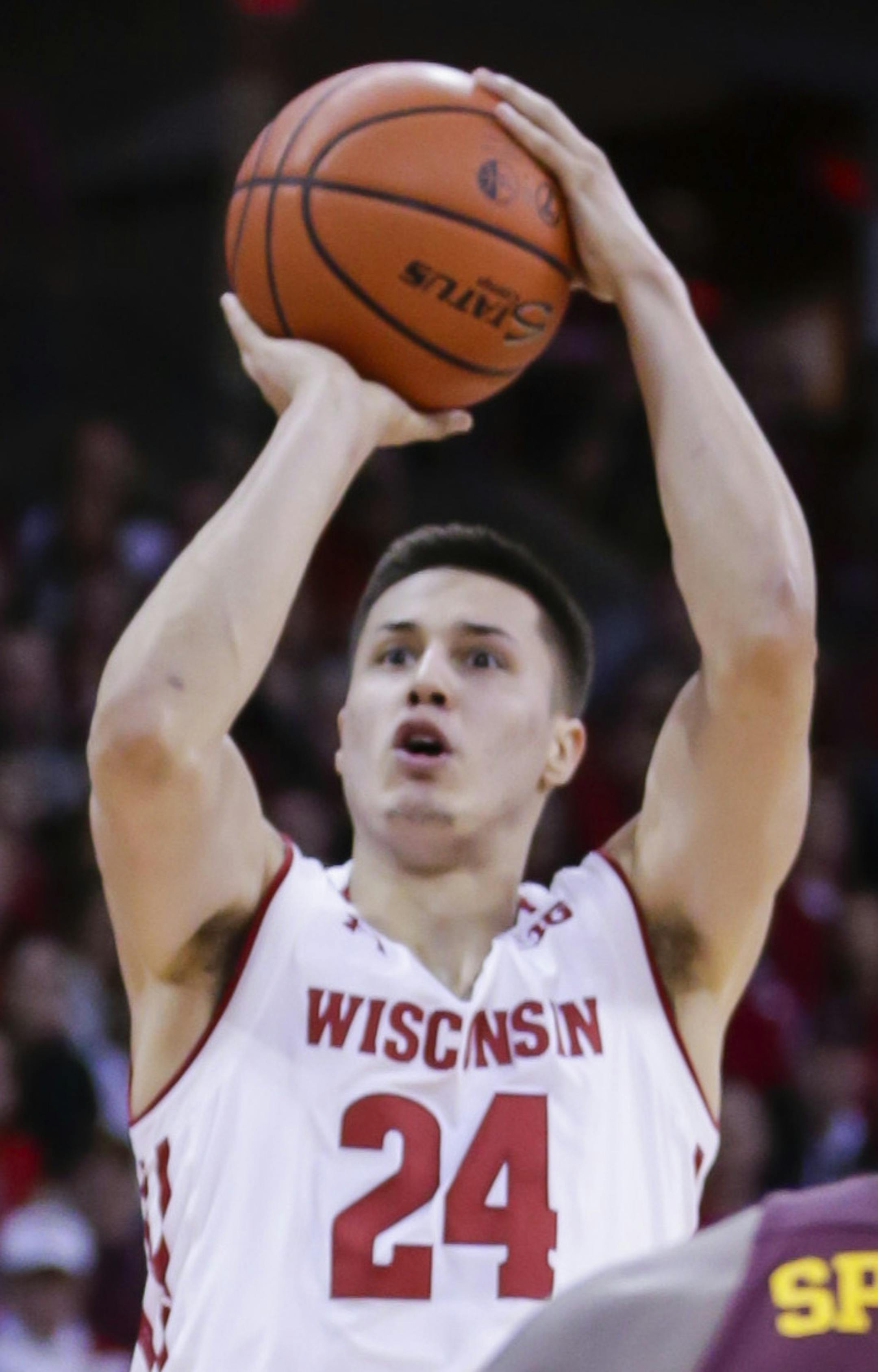 Wisconsin's Bronson Koenig (24) shoots against Minnesota's Dupree McBrayer (1) and Akeem Springs during the second half of an NCAA college basketball game Sunday, March 5, 2017, in Madison, Wis. (AP Photo/Andy Manis)