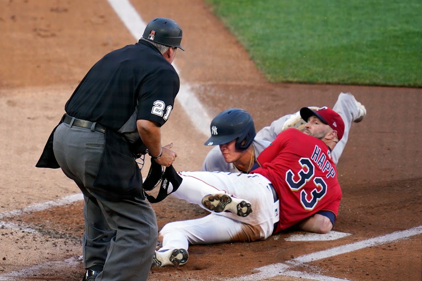 Twins pitcher J.A. Happ looks for the call by umpire Hunter Wendelstedt after tagging Yankees' Gio Urshela at the plate during the first inning