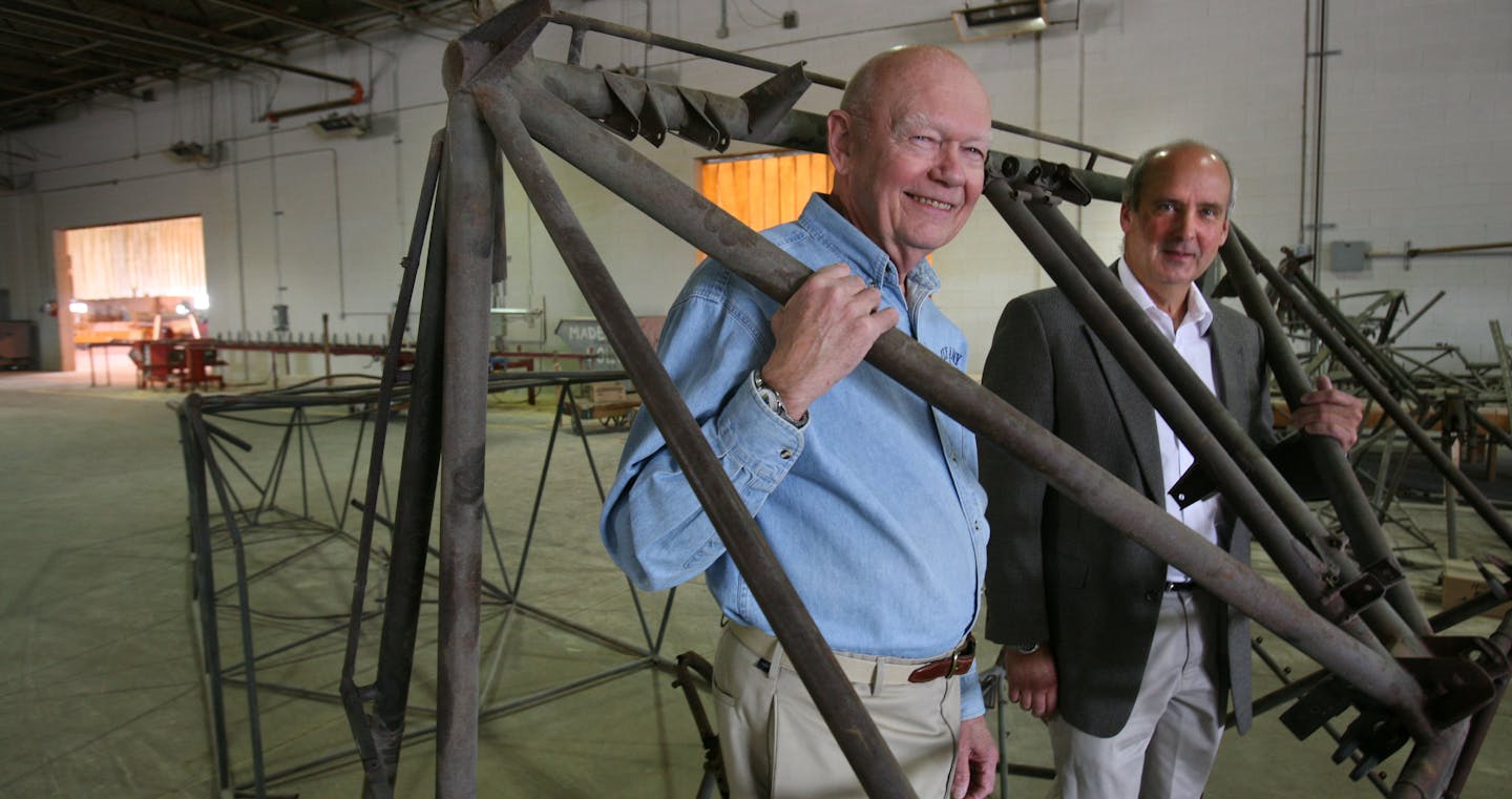 John James, left, and Nick Linsmayer, CEO of Villaume Industries Inc., showed part of the skeleton of a WWII glider. The company made the original wooden parts to the gliders and, with the help of James and others, is planning to rebuild this one.