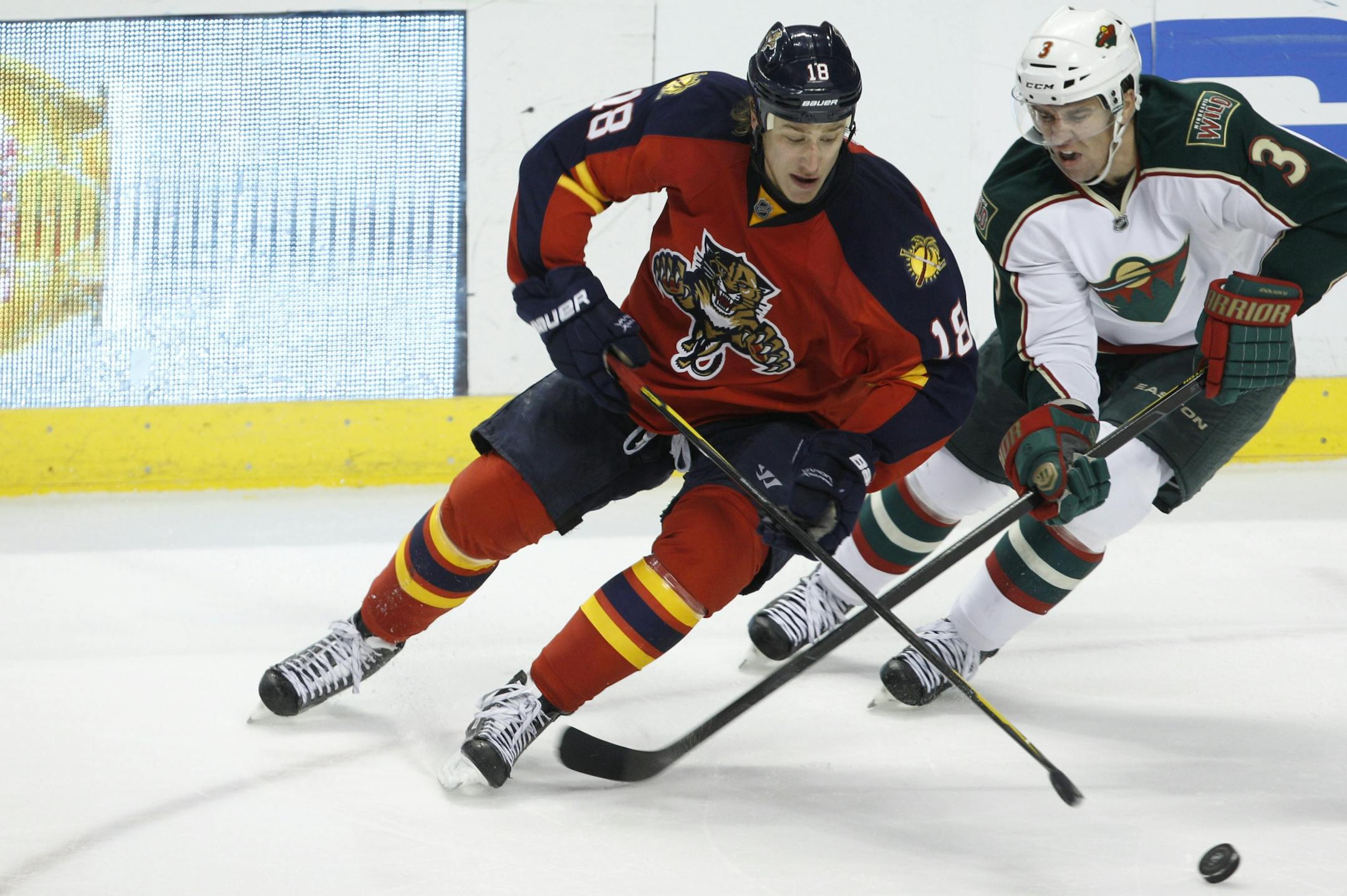 Florida Panthers center Shawn Matthias (18) and Minnesota Wild defenseman Marek Zidlicky (3) chase the puck during the second period of an NHL hockey game, Thursday, Feb. 23, 2012, in Sunrise, Fla.