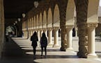 FILE - In this March 14, 2019, file photo students walk on the Stanford University campus in Stanford, Calif.