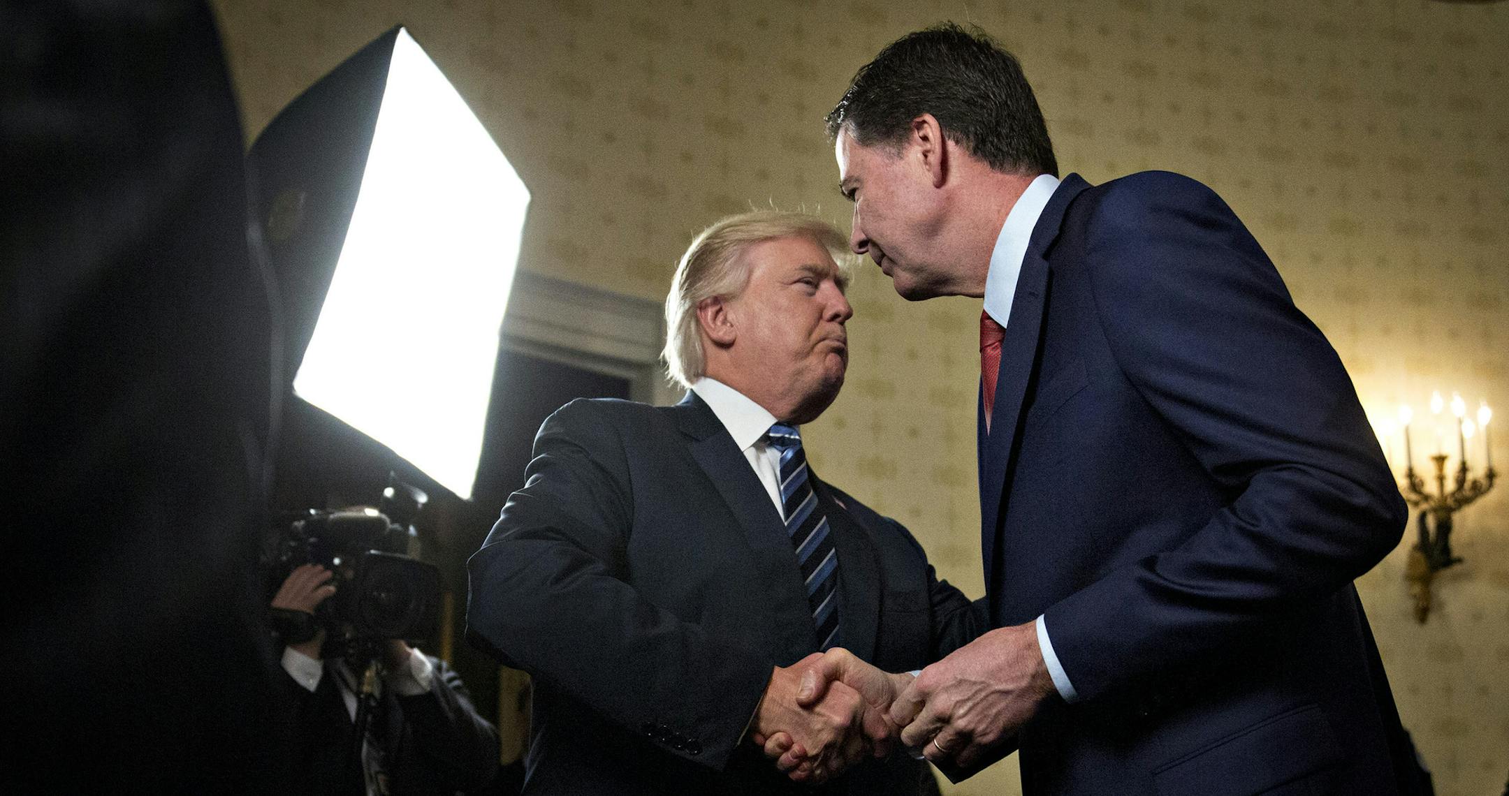 President Donald Trump, left, shakes hands with James Comey, then director of the Federal Bureau of Investigation, in the Blue Room of the White House in Washington, D.C., on January 22, 2017. Trump on June 16 lashed out at the Justice Department official with authority over the special counsel probe of Russian election-meddling, and acknowledged that his firing of Comey as FBI director is a focus of the investigation. (Andrew Harrer/Pool/Sipa USA/TNS) ORG XMIT: 1228496