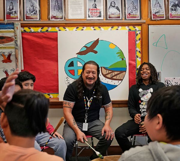 American Indian Magnet School teacher Thomas Draskovic, center, shares a light moment with seventh-grader Davion Williams, right, during practice with