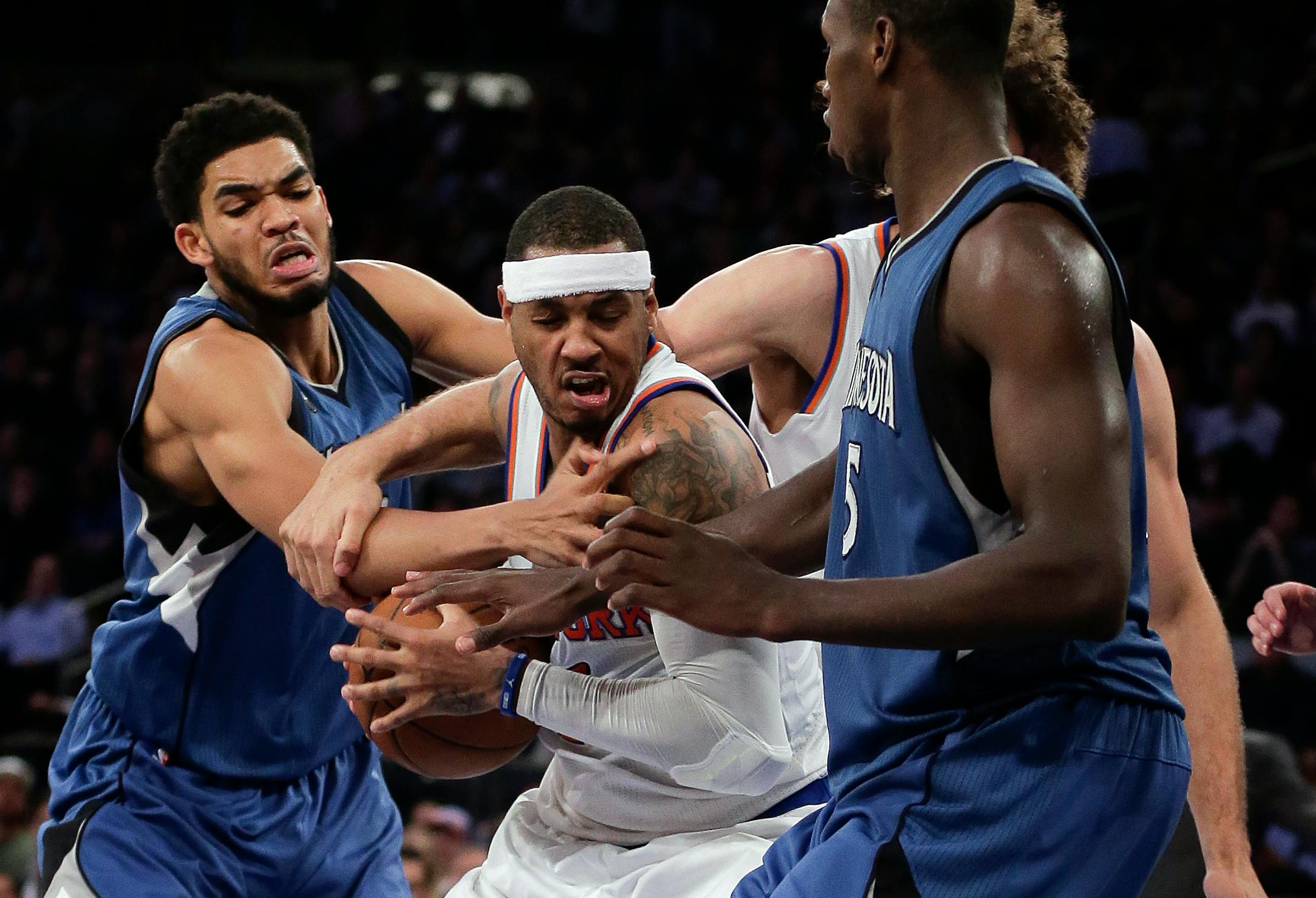 Knicks forward Carmelo Anthony, center, was double-teamed by the Timberwolves' Karl-Anthony Towns, left, and Gorgui Dieng during the fourth quarter Wednesday in New York. The Knicks won 107-102.
