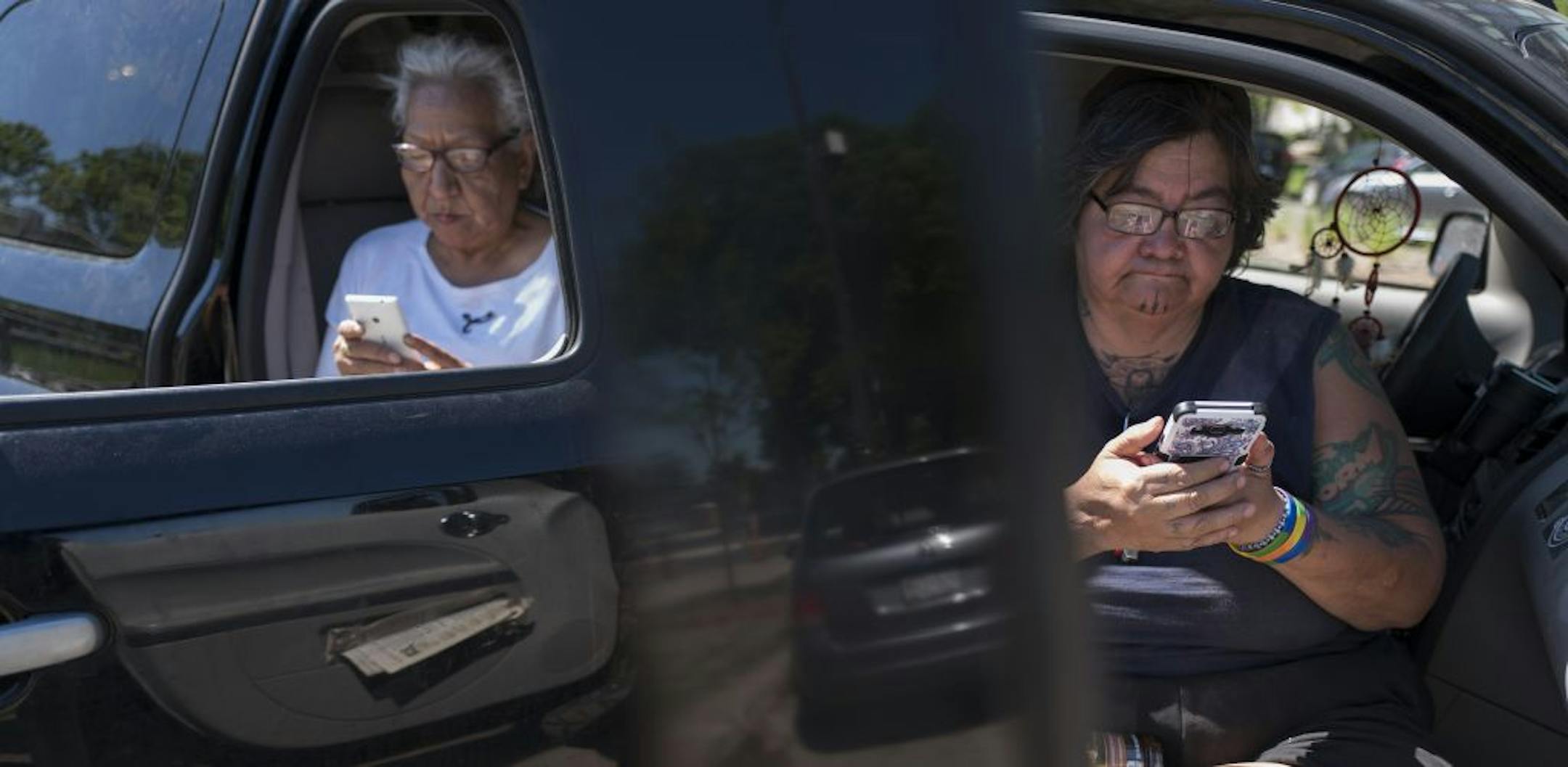 Geraldine Cole, left, and Sue GoodStar saved photos on their phones after taking picture of the site where protests were held against the "Scaffold" sculpture.