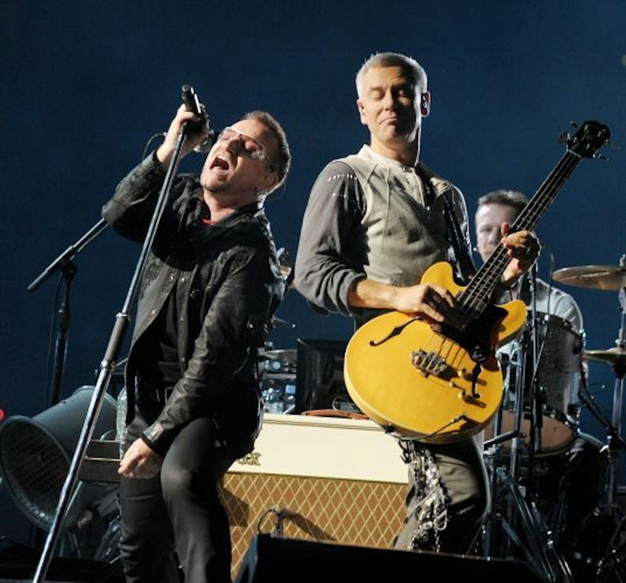 Singer Bono (L) and musician Adam Clayton of U2 perform onstage during their "360 Degrees Tour" at the Rose Bowl on Oct. 25 in Pasadena, Calif.