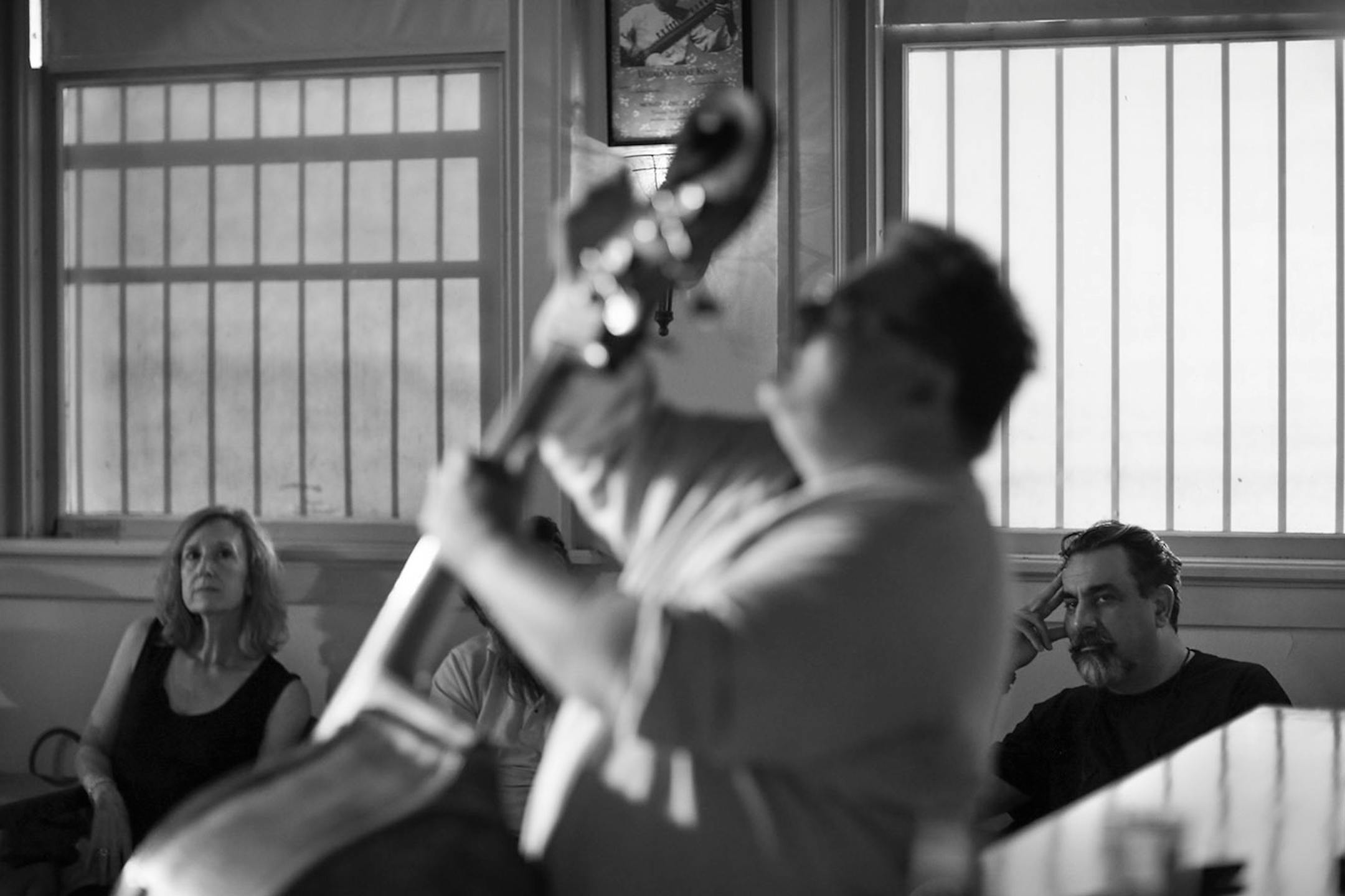Anne Parks, left, and Khyber Pass owner Emel Sherzad listened to Adam Linz, shown, and Schris Bates' bass duets during a Thursday night jazz program at the cafe earlier this month.