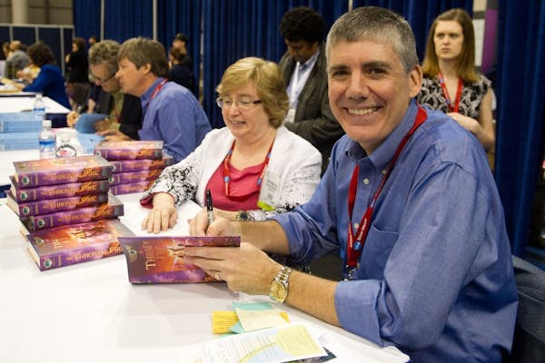 Author Rick Riordan signs copies of his books at the Book Expo America in New York, Wednesday, May 25, 2011.