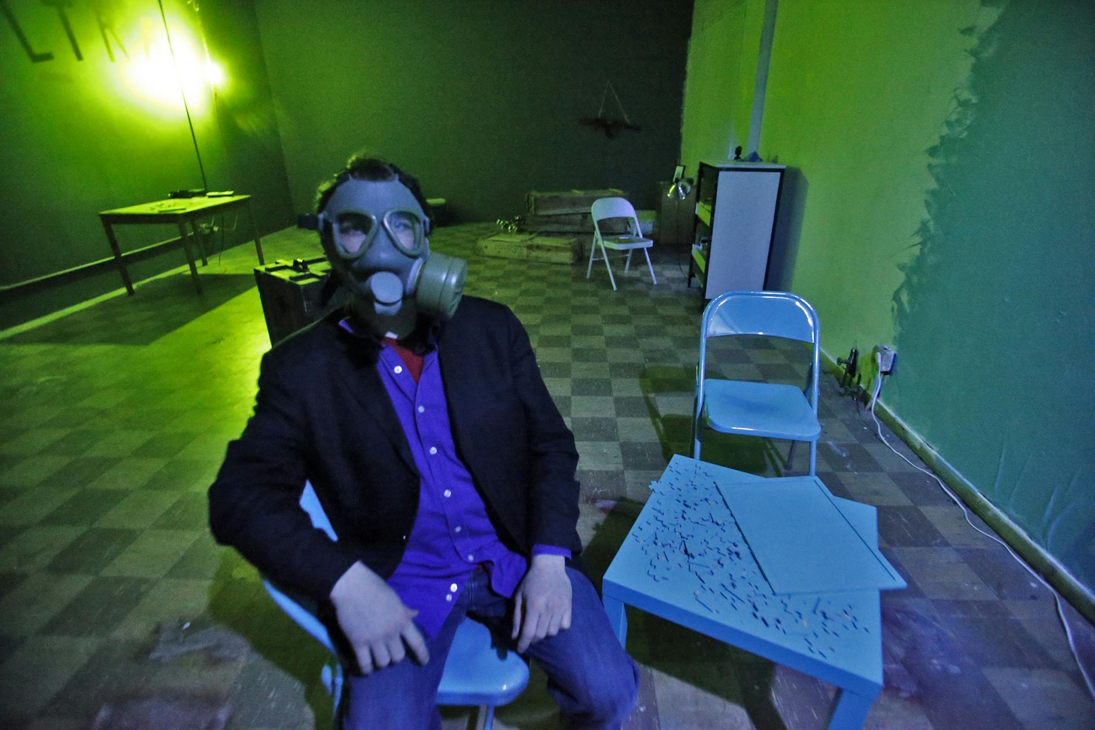Riddle Room host Donavon Cawley wearing a gas mask that is one of the clues found in the riddle room.