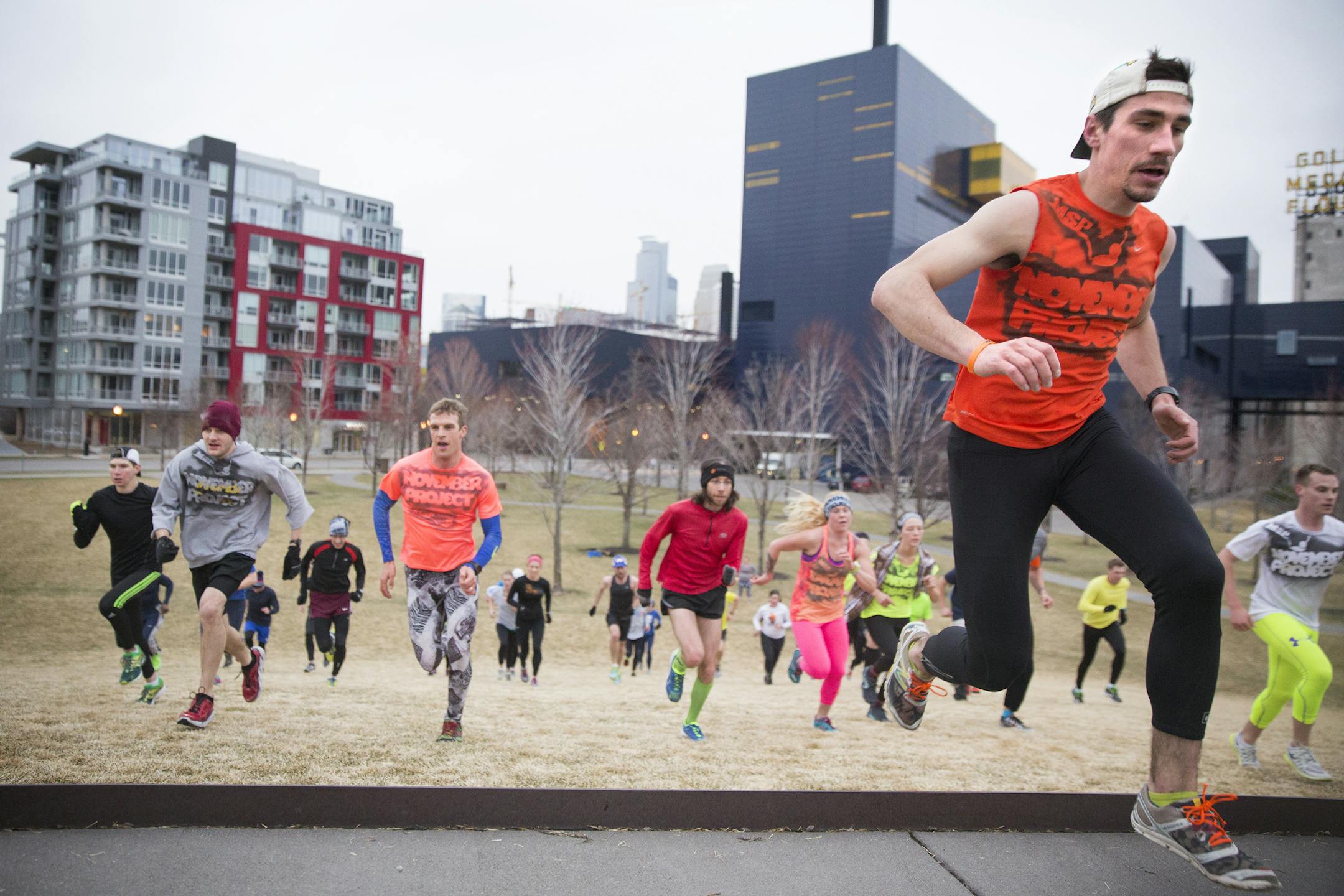 Tribe leader Ben Bauch, right, runs hill sprints at Gold Medal Park with the group during a meeting of the November Project workout group in downtown Minneapolis on Wednesday, April 8, 2015. ] LEILA NAVIDI leila.navidi@startribune.com / BACKGROUND INFORMATION: The November Project is a flash-mob style free workout movement that meets every Wednesday at 6:27 a.m. in downtown Minneapolis to work out and build community.