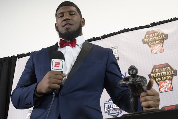 FILE - In this Dec. 7, 2017, file photo, Houston defensive tackle Ed Oliver, winner of the Outland Trophy for outstanding interior lineman, stands wit