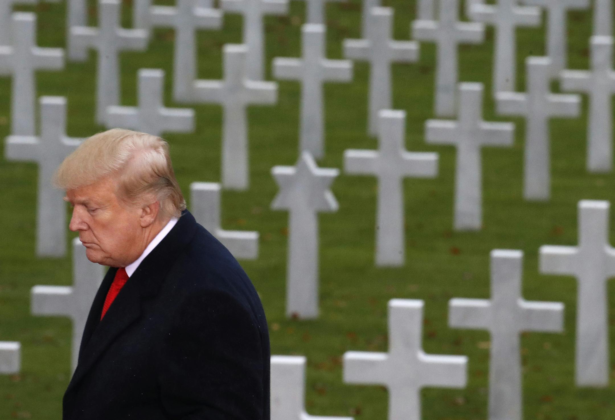 President Donald Trump is backdropped by headstones as he prepares to speak during an American Commemoration Ceremony, Sunday Nov. 11, 2018, at Suresnes American Cemetery near Paris. Trump is attending centennial commemorations in Paris this weekend to mark the Armistice that ended World War I. (AP Photo/Jacquelyn Martin)