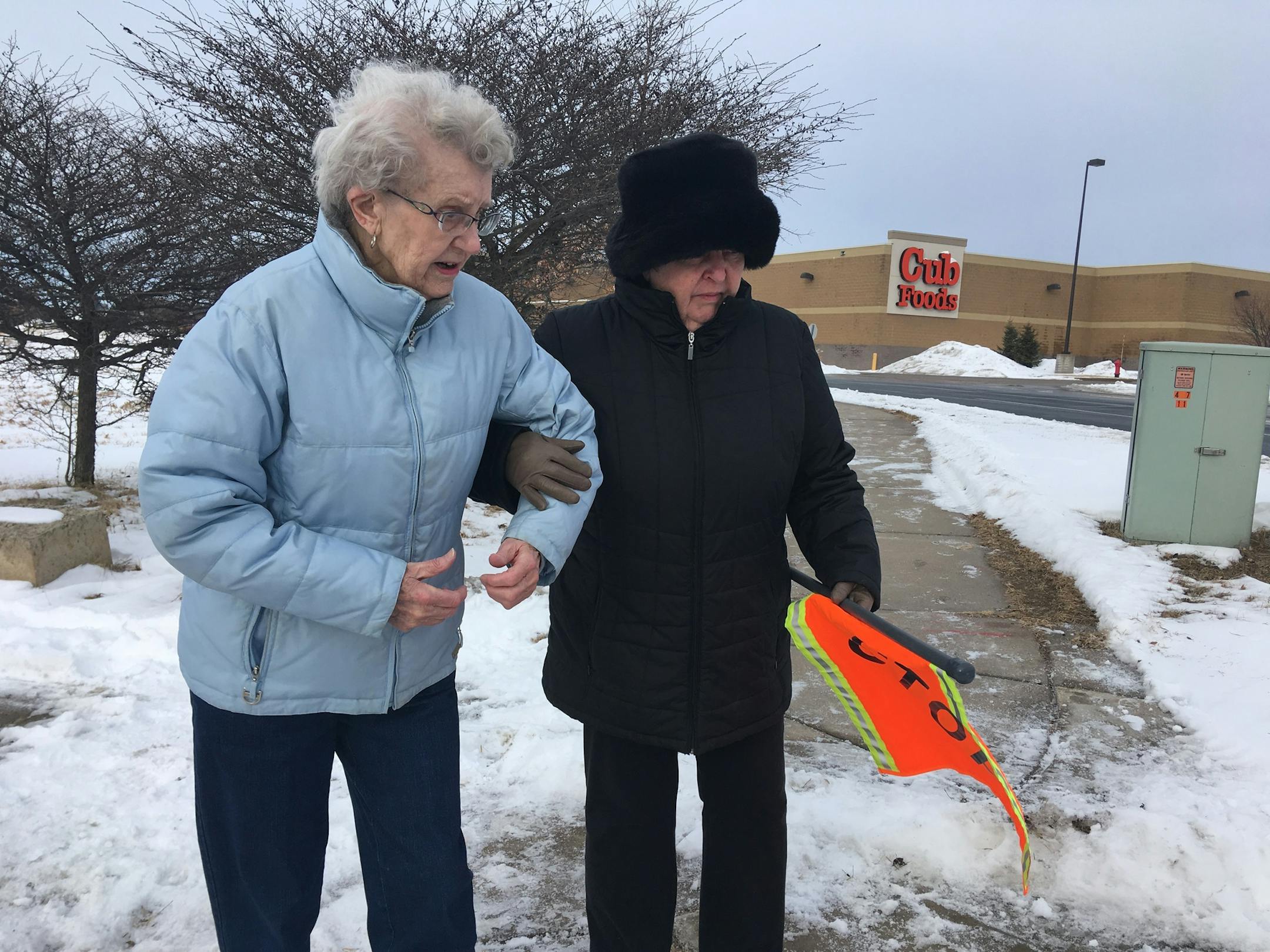Marjorie Kleven and friend Carol Schlomka try out the new pedestrian flags in Hastings.
