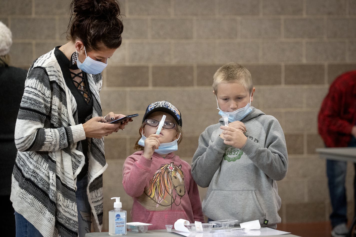 Tammi Bertram and her children Kristalyn, 6, center, and Bentley, 9, took a COVID-19 test at the new saliva testing center in Inver Grove Heights, Wednesday, November 18, 2020. ] ELIZABETH FLORES • liz.flores@startribune.com