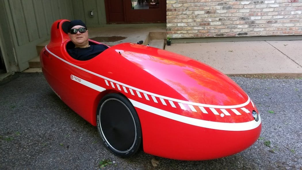 Lutheran pastor Chirstopher Hagen of Plymouth in his velomobile, a three-wheeled recumbent bike with a fully enclosed, streamlined fiberglass body. His velomobile journeys are “meditative,” he said.