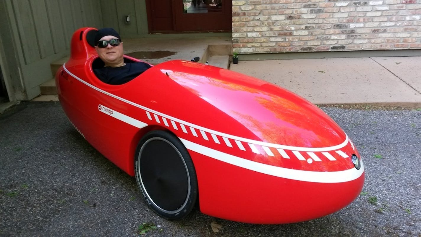 Lutheran pastor Chirstopher Hagen of Plymouth in his velomobile, a three-wheeled recumbent bike with a fully enclosed, streamlined fiberglass body. His velomobile journeys are "meditative," he said.