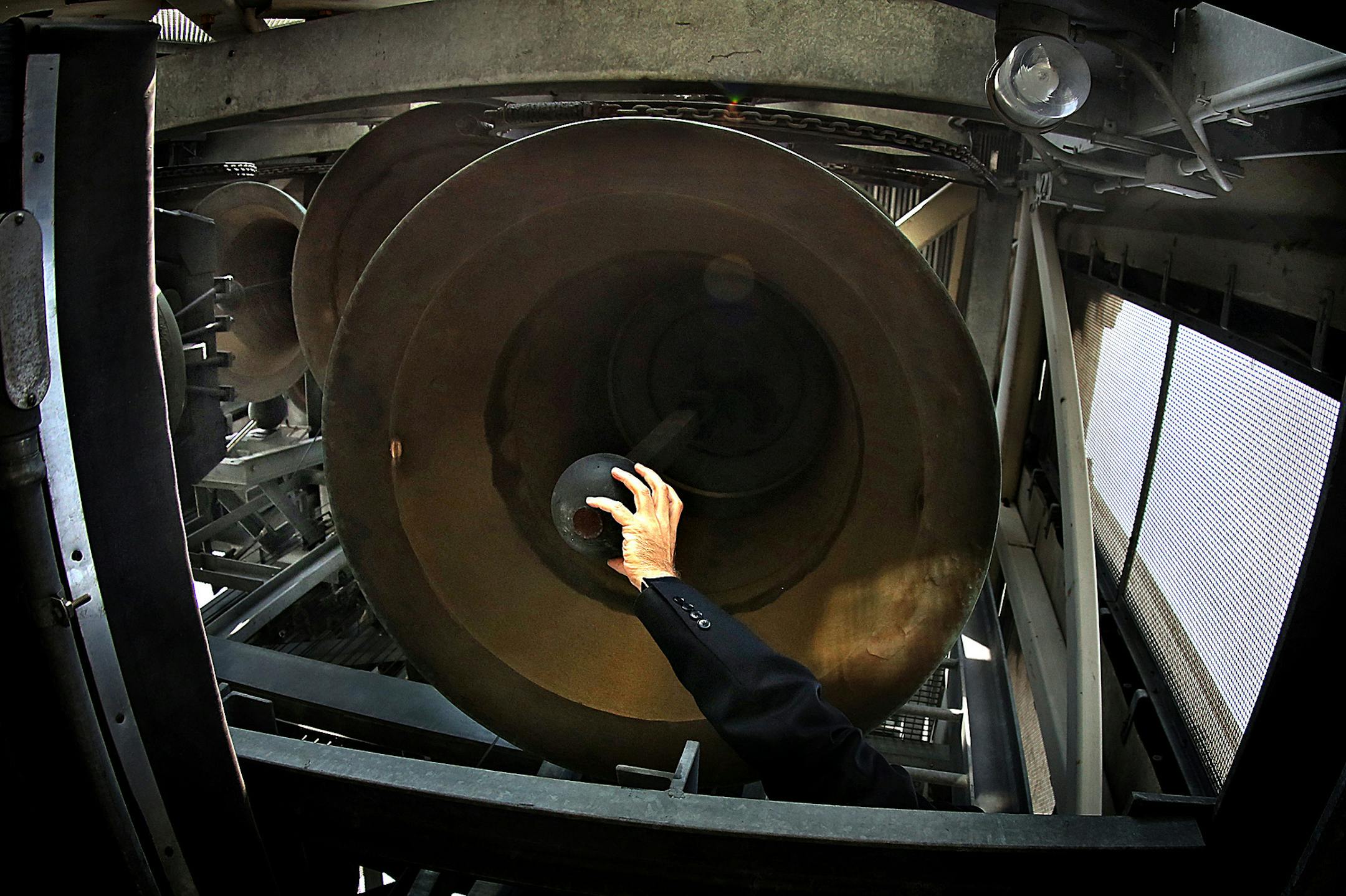Central Lutheran’s restored bell tower holds 47 bells, top, that are connected to the keys — called batons — of a carillon that sits directly beneath them, left. The Rev. Foy Christopherson reached up, right, to swing the clapper in one of the larger bells, which weighs as much as an SUV.