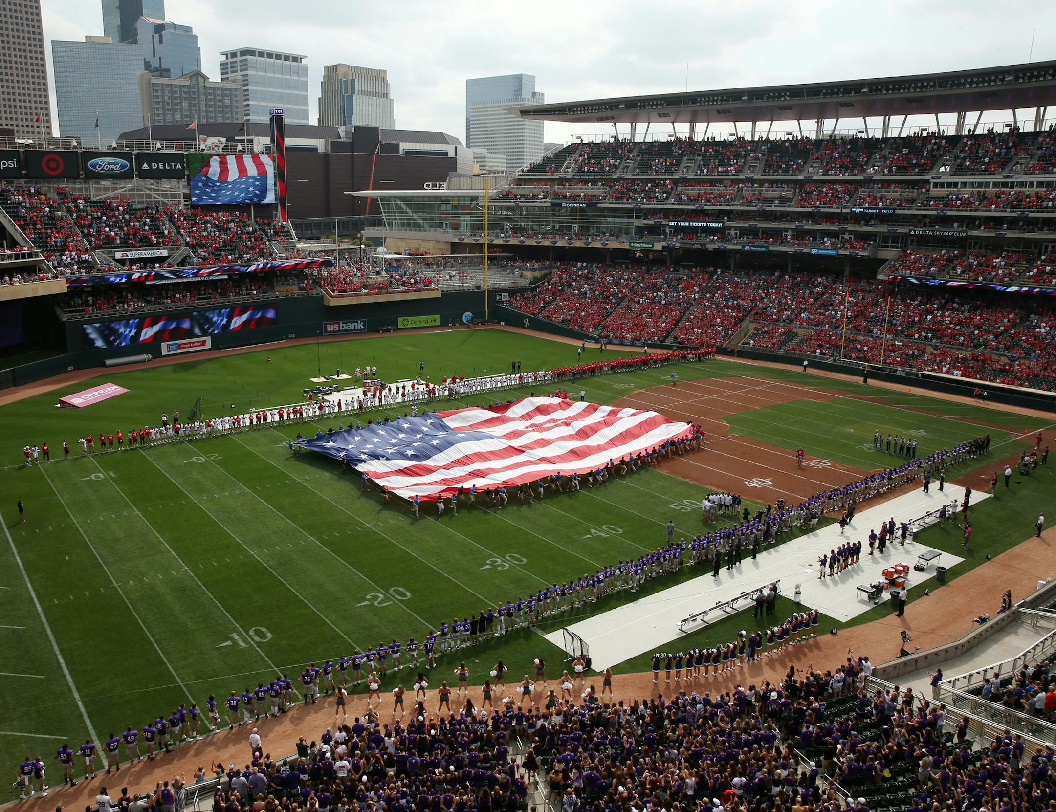 Fans watched as a giant American fly was unfurled on the field in preparation for the National Anthem Saturday. ] ANTHONY SOUFFLE &#xef; anthony.souffle@startribune.com Game action from an NCAA football game between the University of St. Thomas and St. John's University Saturday, Sept. 23, 2017 at Target Field in Minneapolis.