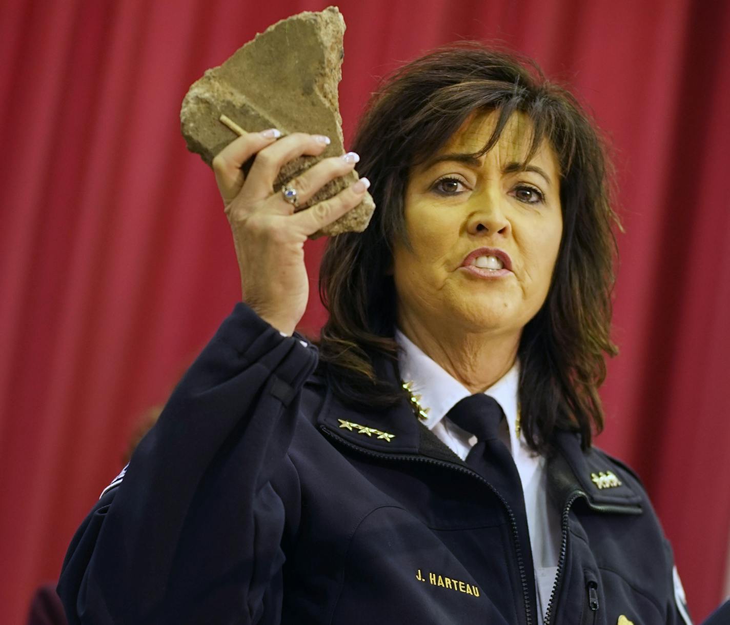 Minneapolis Police Chief Janee Harteau holds a rock thrown at police during a protest at the Minneapolis Police Department 4th Precinct building Thursday, Nov. 19, 2015, during a news conference in Minneapolis. The rock was thrown Wednesday evening as people protested the fatal shooting of Jamal Clark by Minneapolis police on Sunday. (Richard Tsong-Taatarii/Star Tribune via AP) MANDATORY CREDIT; ST. PAUL PIONEER PRESS OUT; MAGS OUT; TWIN CITIES LOCAL TELEVISION OUT ORG XMIT: MIN2015111919401991