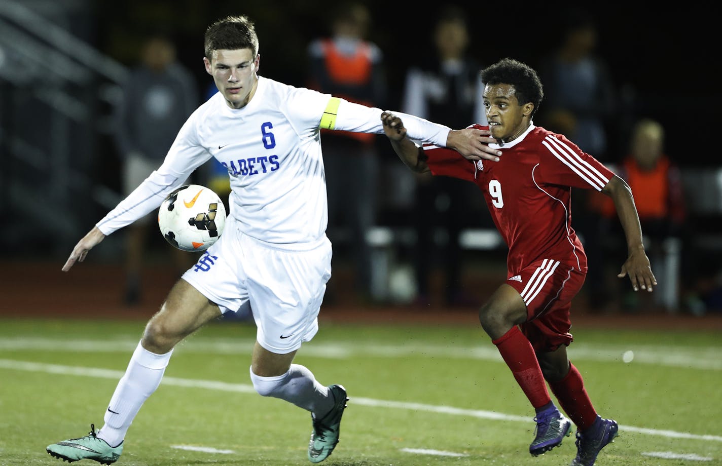 St. Thomas Academy senior William Mayleben, left, kept the ball away from St. Paul Highland Park's Abdi Gutu during the Class 1A, Section 3 semifinals on Tuesday.