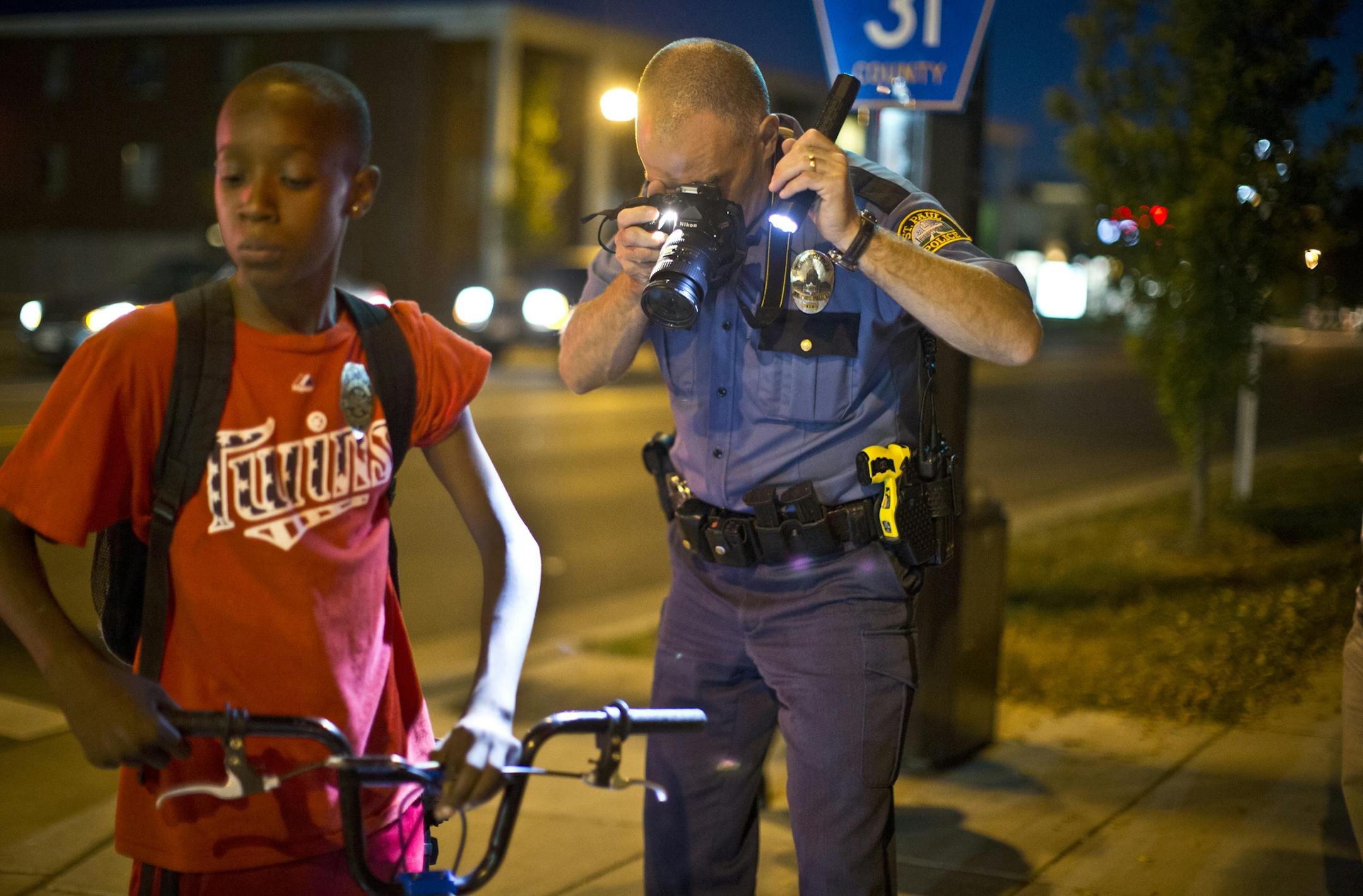 Officer Tom Tanghe investigated a scene where a kid was hit while riding his bike Payne Phalen neighborhood in St. Paul, Minn. on Tuesday, August 12, 2013. The driver sped off after the incident. The kid appeared unharmed. ] (RENEE JONES SCHNEIDER &#x2022; reneejones@startribune.com)
