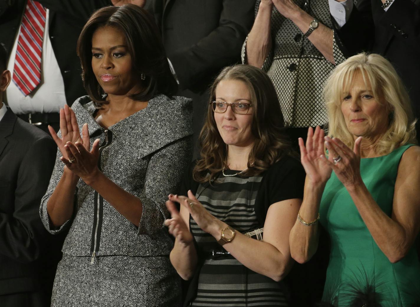 First lady Michelle Obama applauds on Capitol Hill in Washington, Tuesday, Jan. 20, 2015, before President Barack Obama's State of the Union address before a joint session of Congress. From left are, Anthony Mendez, Mrs. Obama, Rebekah Erler and Jill Biden. (AP Photo/J. Scott Applewhite) ORG XMIT: MIN2015012020213406