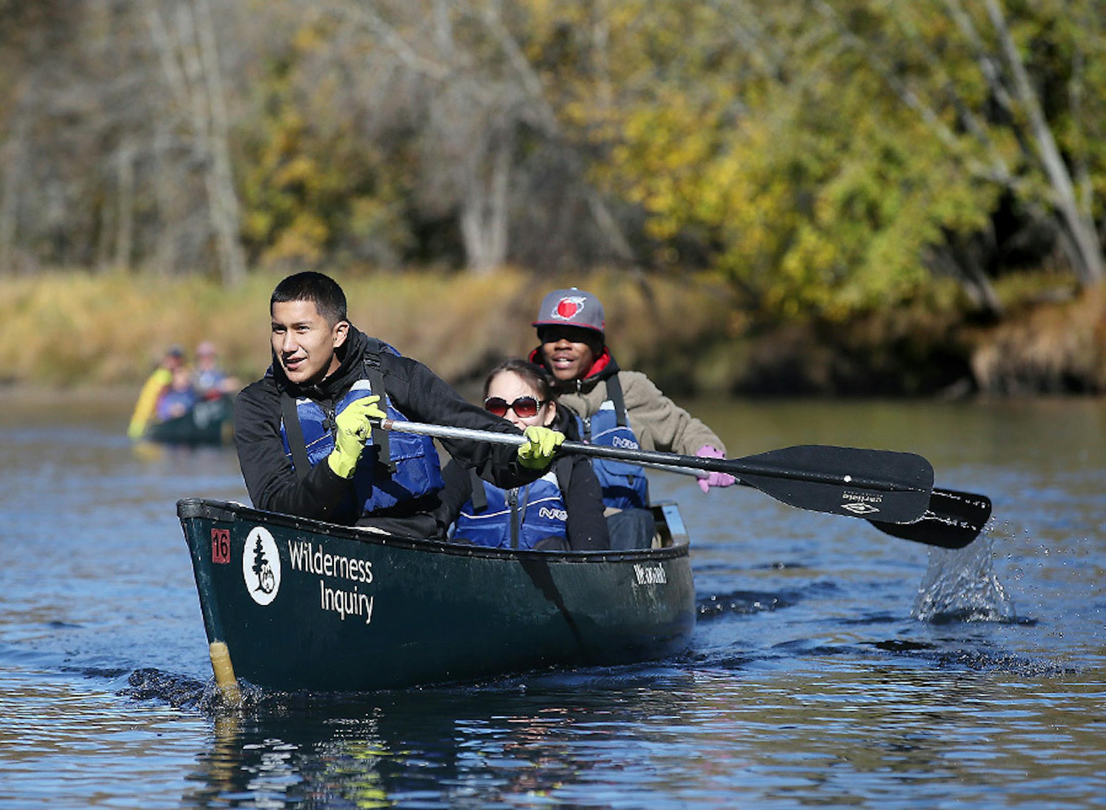 Lowan Badhand, left, Kaleena Morrison, center, and Terrell McCray canoed up the Rum River to find spots to help plant wild rice seeds, Tuesday, October 13, 2015 near Cambridge, MN.