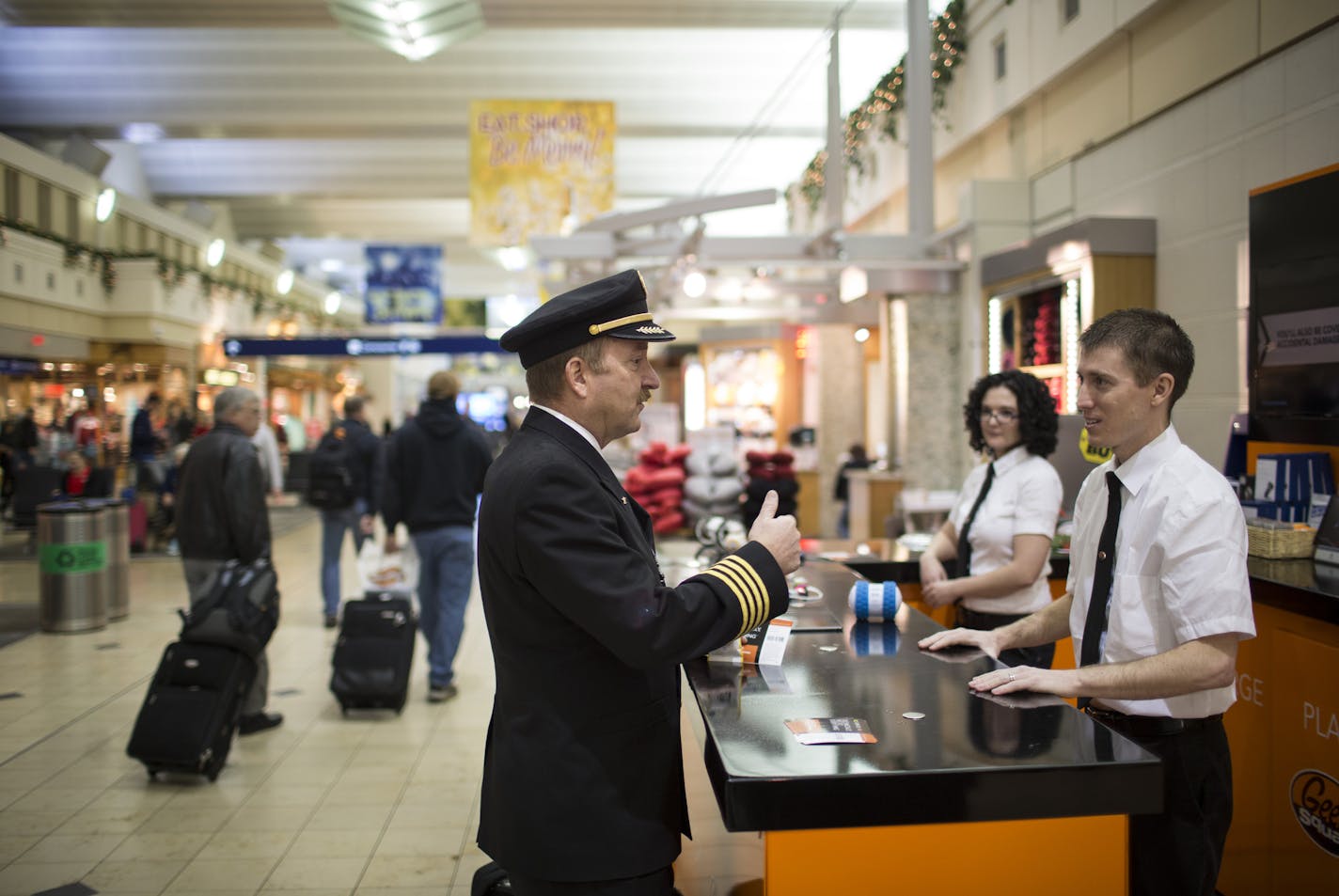 Geek Squad "double agent" William Woodworth CQ, right, helped answer some questions about iPads from pilot Robert Hardcopf CQ before his flight at a pop-up Geek Squad counter on Monday, December 14, 2015, at Terminal 1 at the Minneapolis/St. Paul Airport in Bloomington, Minn. ] RENEE JONES SCHNEIDER &#x2022; reneejones@startribune.com