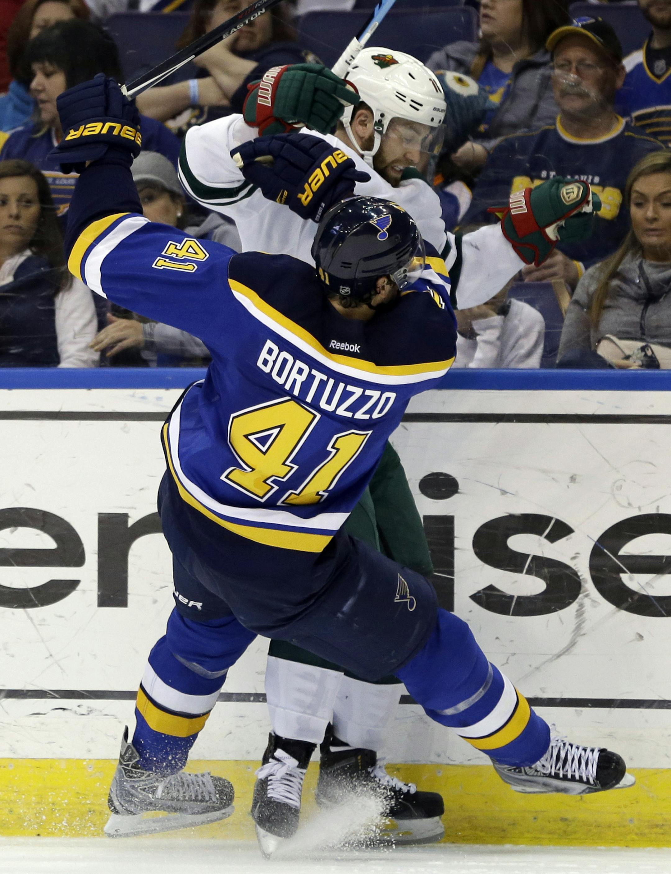 St. Louis Blues' Robert Bortuzzo (41) collides with Minnesota Wild's Jason Zucker along the boards during the third period of an NHL hockey game Saturday, April 11, 2015, in St. Louis. The Blues won 4-2. (AP Photo/Jeff Roberson)
