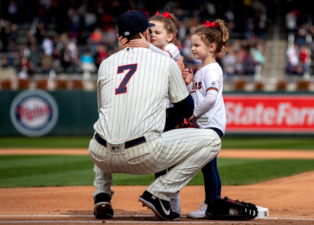 Minnesota Twins first baseman Joe Mauer got a hug and kiss from his twin daughters before the start of the game .